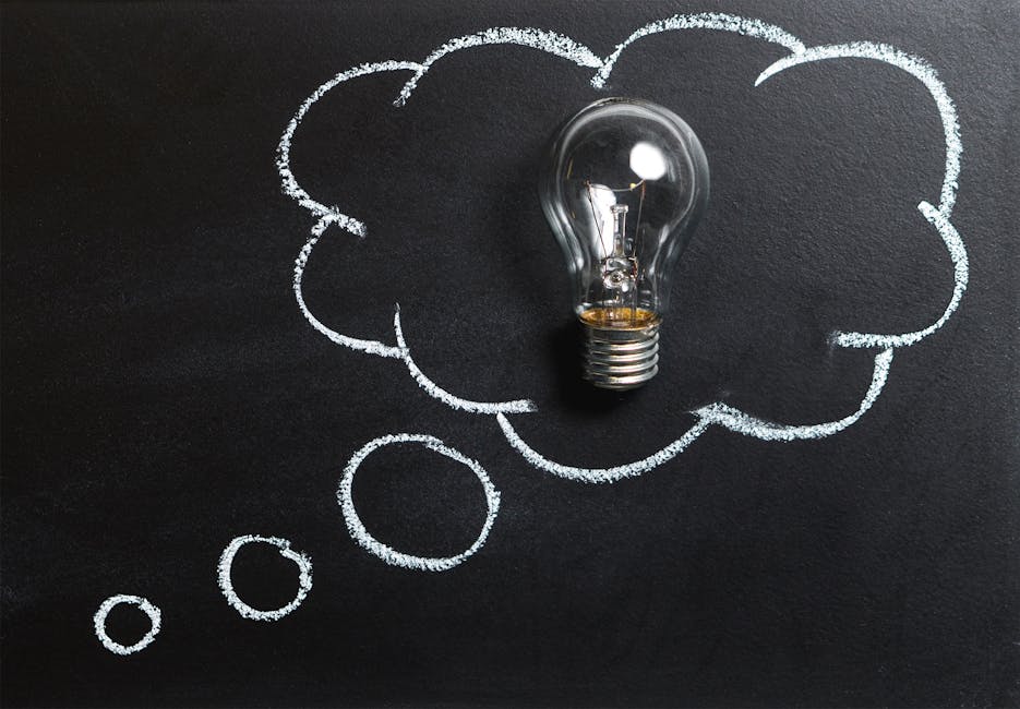 Light bulb laying on chalkboard with drawn thought bubble, symbolizing creative ideas