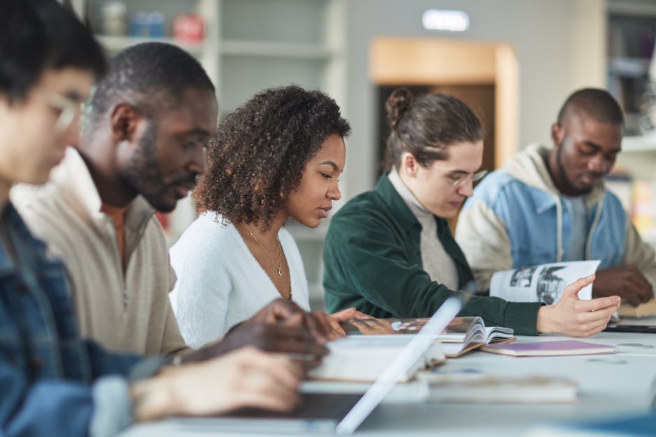 Multiracial group of college students studying together indoors in a library